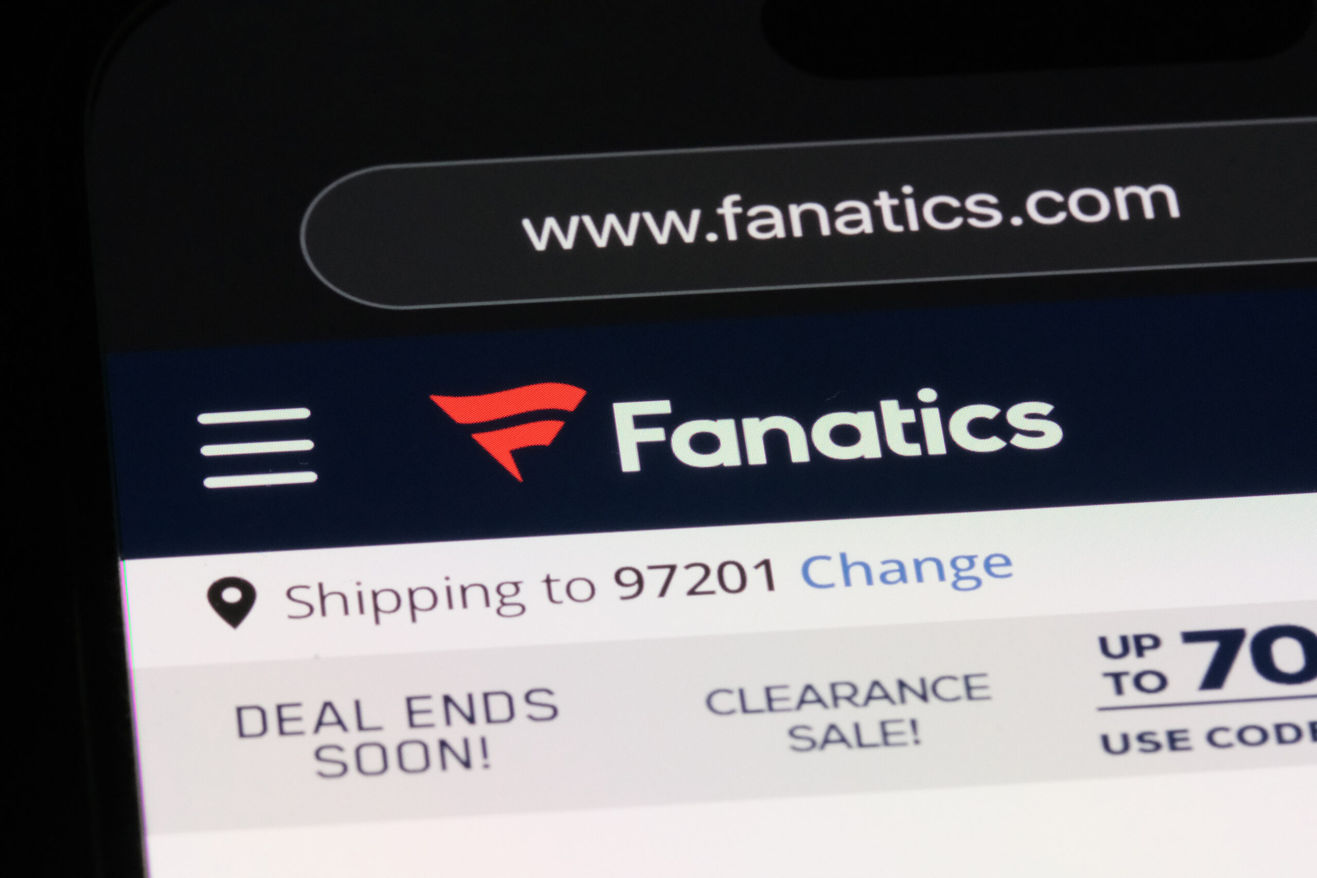 Close-up of a mobile screen showing the Fanatics website header with logo and navigation elements, URL www.fanatics.com visible.